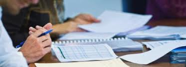 a picture of a man going over a spreadsheet